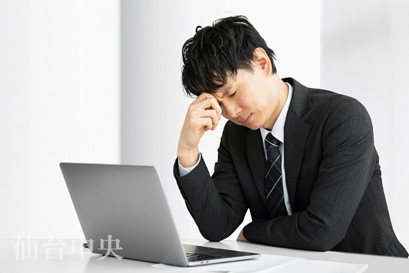 切開したくないので切らない包茎手術をパソコンで検索する男性